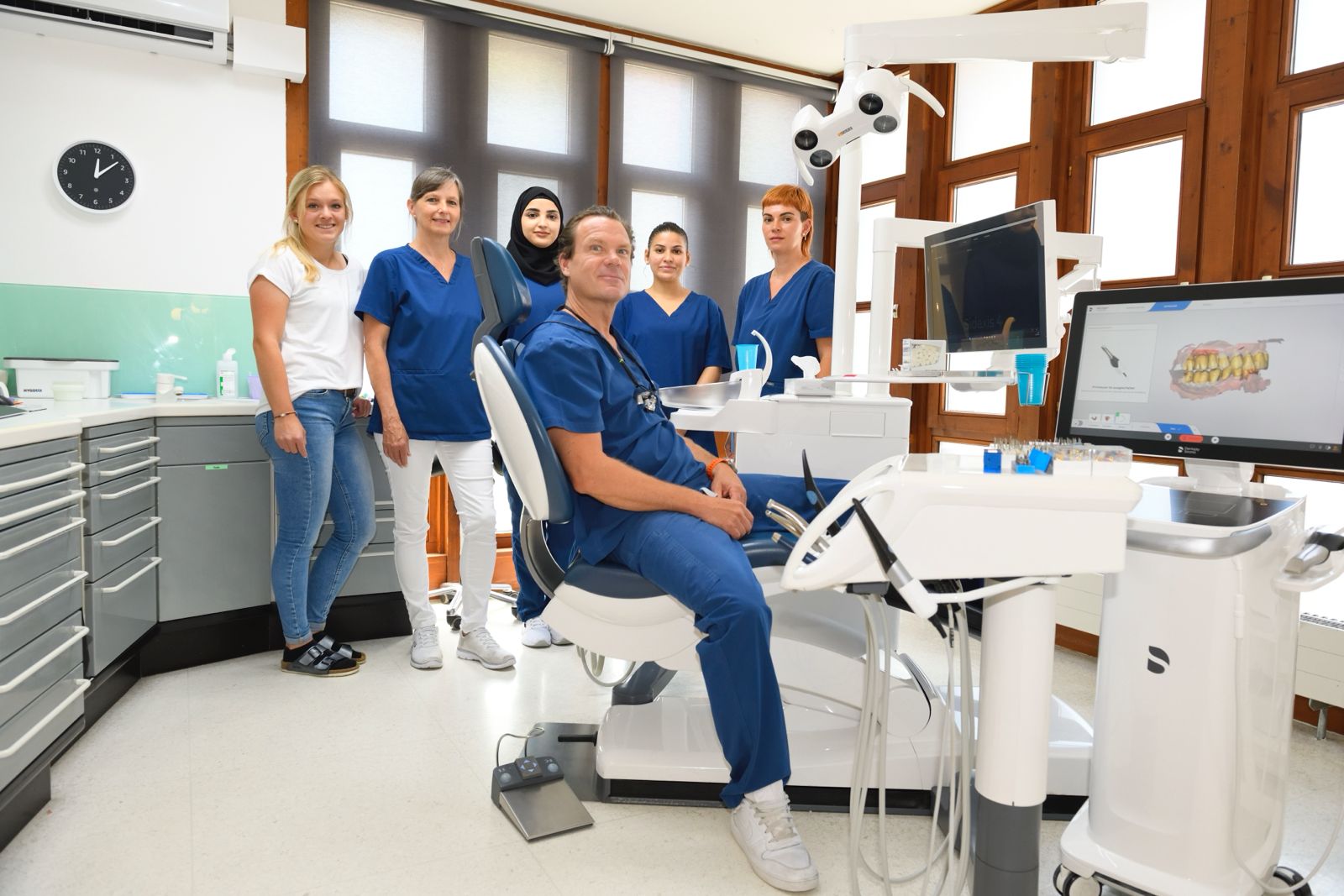 Team der Zahnarztpraxis Fischer gemeinsam im Behandlungszimmer